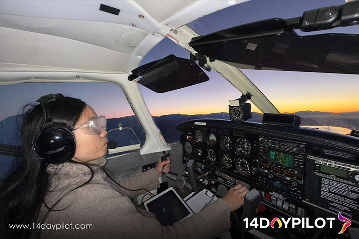 Female student pilot wearing headset while practicing communication at sunset